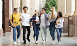 Group of diverse college students walking together on campus, smiling and holding books—representing the energy and engagement behind a successful event planning checklist for campus events.